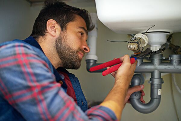 Hes a pro at plumbing. Shot of a plumber fixing a pipe